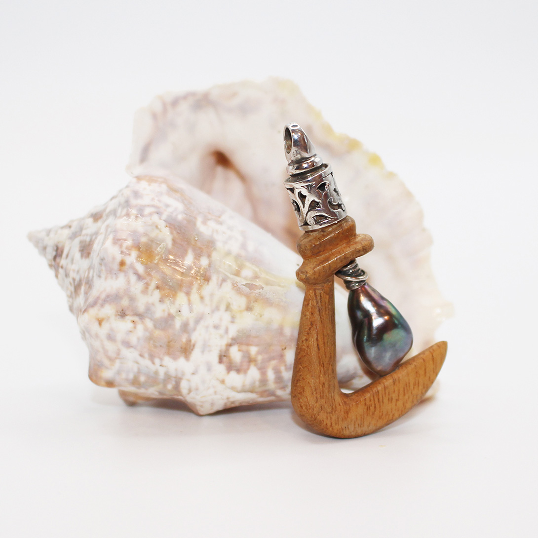 A picture of a cedar anchor with a Tahitian black pearl and sterling silver neck.
