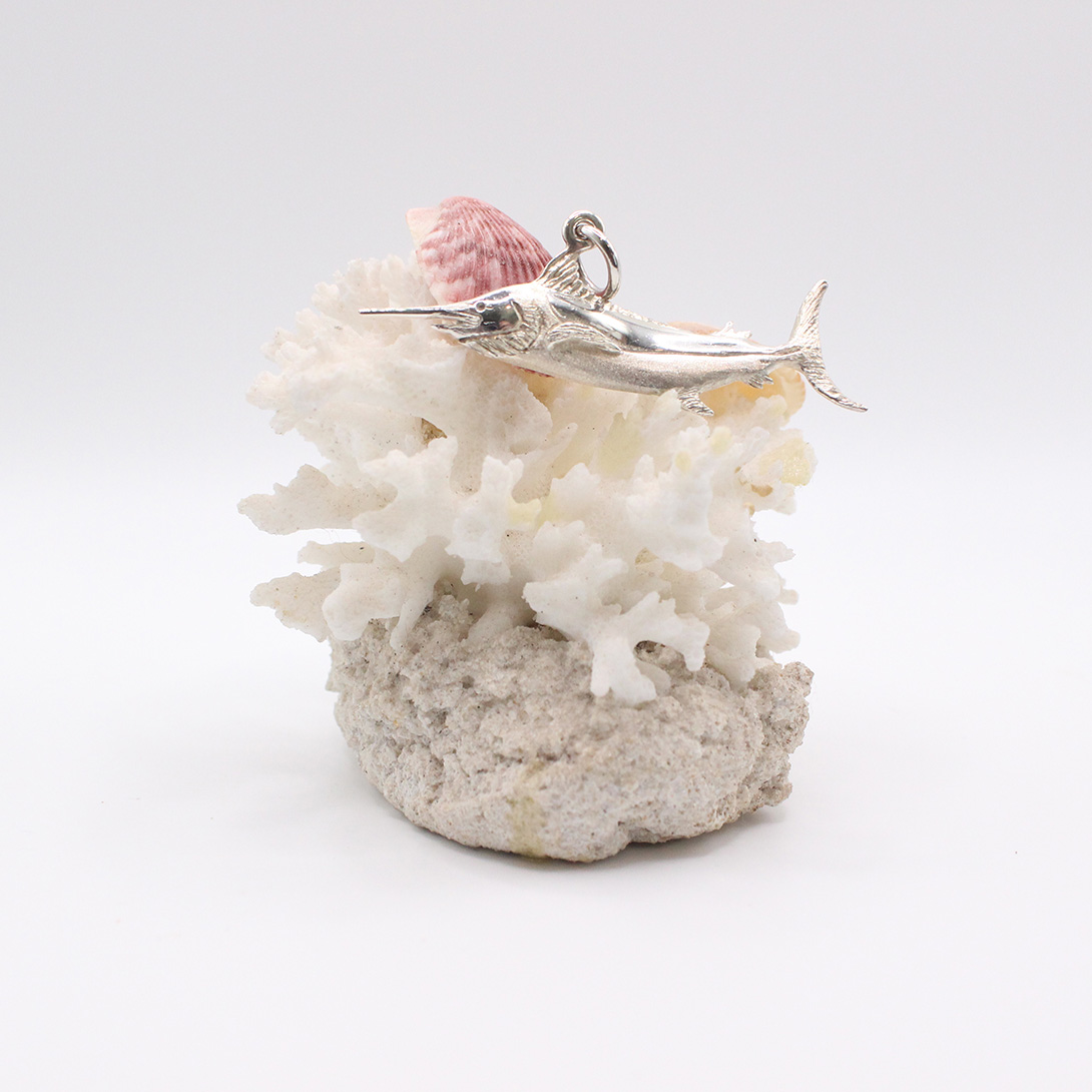 A silver tarpon pendant with saphire eyes.